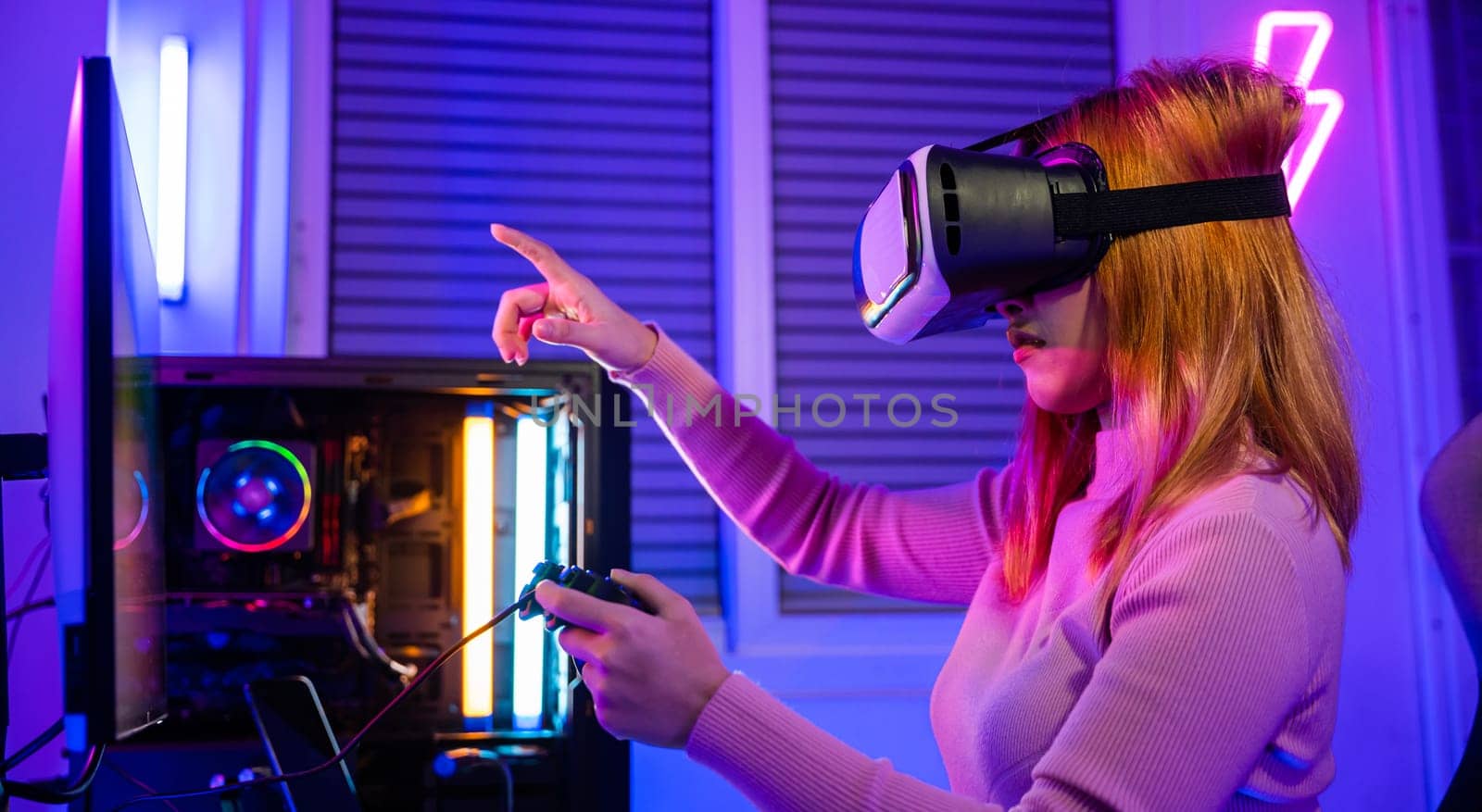 Excited woman playing watching video life simulation at home, Gamer in VR headset glasses exploring metaverse plays online video game touching something on air with neon lights, E-Sport metaverse