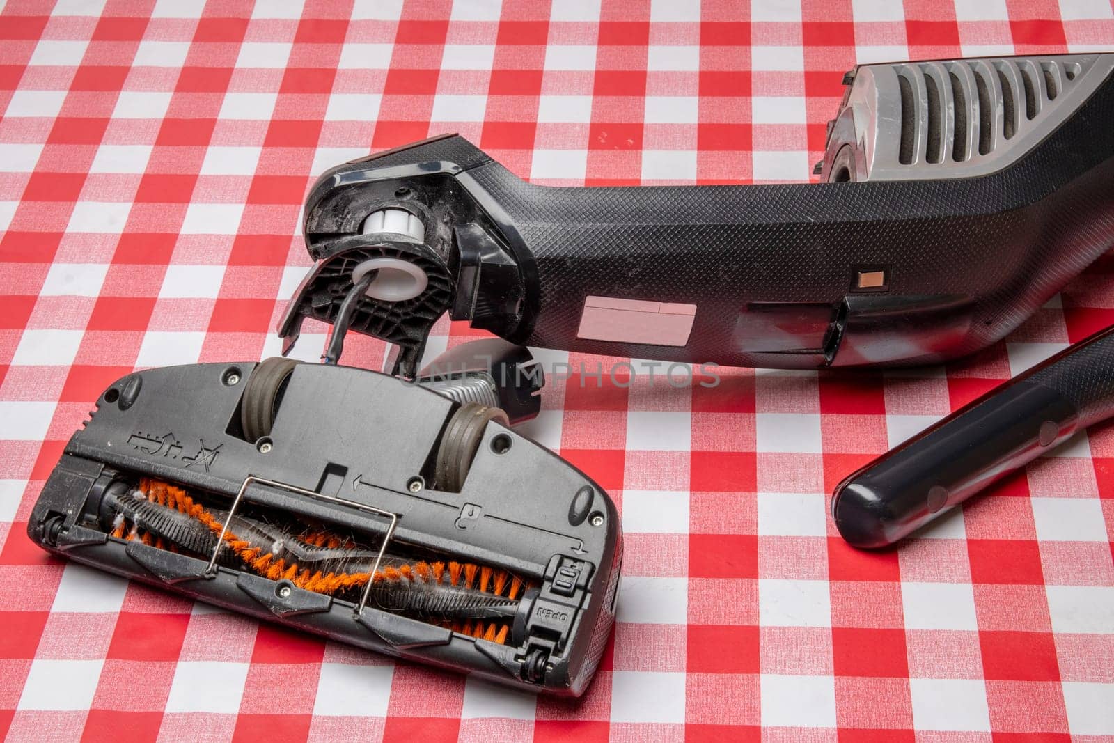 Repair of household appliances. Professional technician repairs a vacuum cleaner. Household appliances customer service. Battery hoover. Repair by a specialist on site.