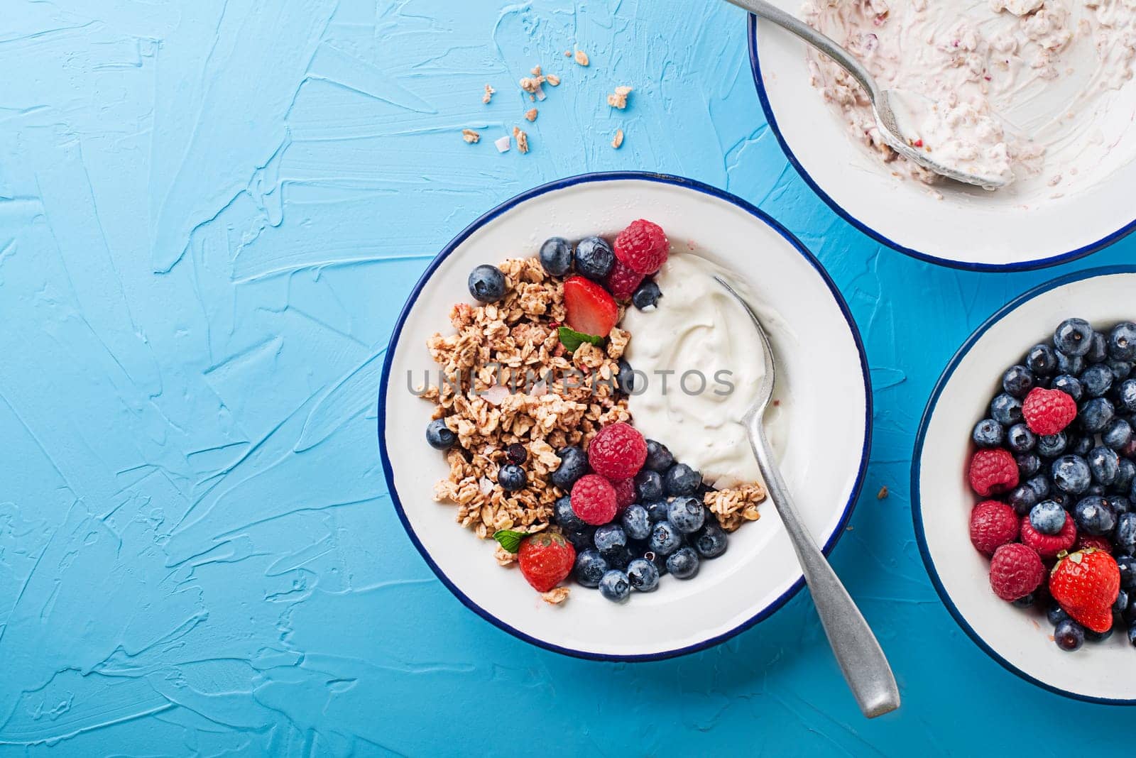 A plate of dry granola served with fresh berry fruit and yogurt. Oatmeal plate. Healthy food, diet. Top view.