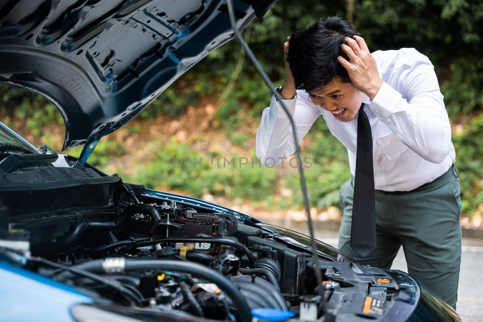 Asian businessman car broken breakdown, young stressed man having trouble car failure problem looking in frustration at failed engine in the morning, accident on road outdoor, late for work
