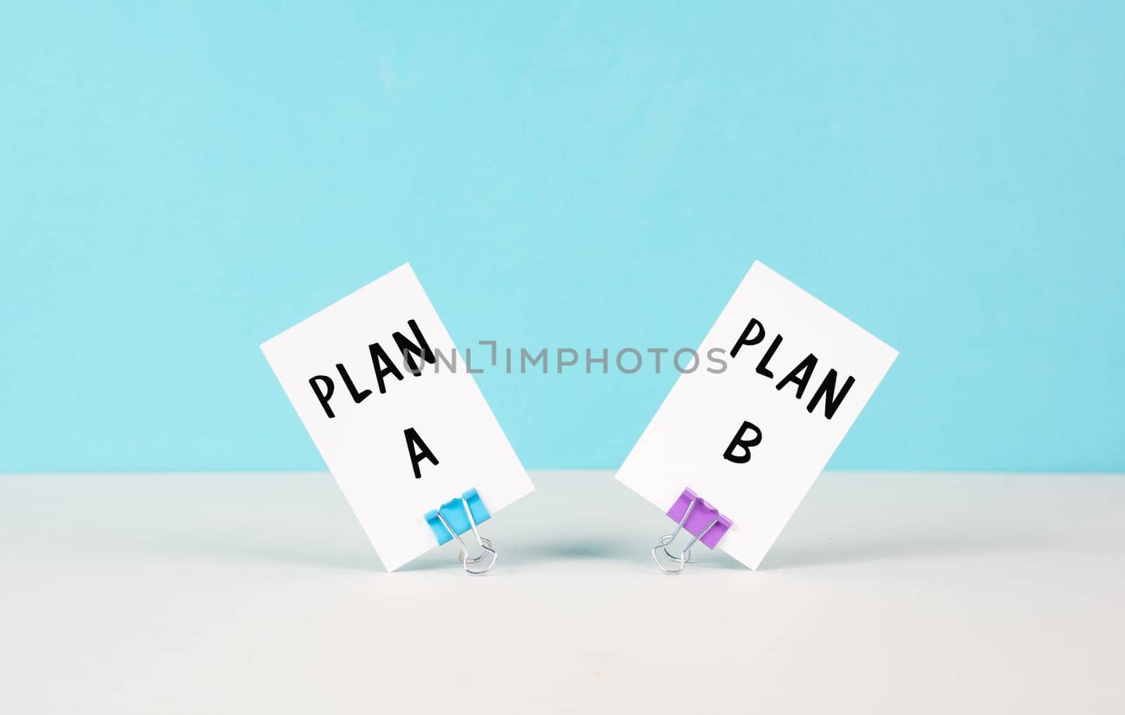 Plan A and B standing on paper, brainstorming for possibilities, making a decision