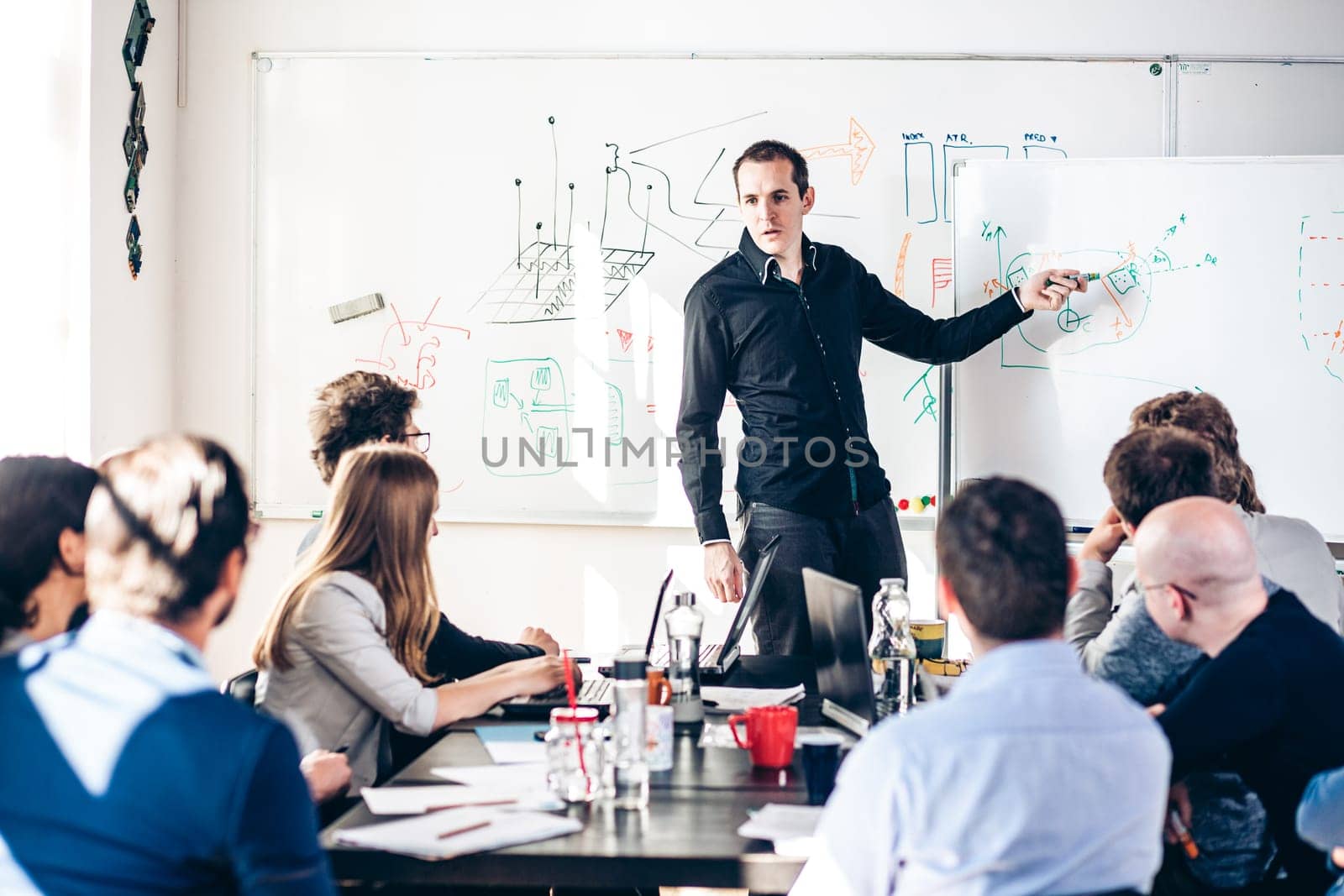 Relaxed informal IT business startup company meeting. Team leader discussing and brainstorming new approaches and ideas with colleagues. Startup business and entrepreneurship concept.