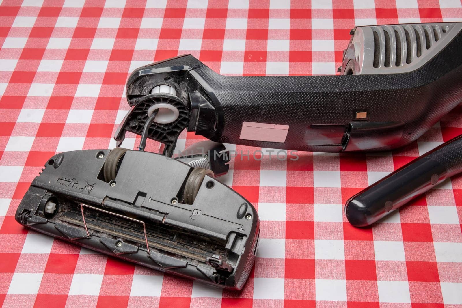 Repair of household appliances. Professional technician repairs a vacuum cleaner. Household appliances customer service. Battery hoover. Repair by a specialist on site.
