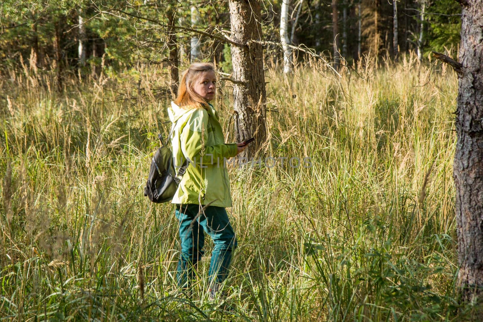 Woman play Geocaching. Walk in deep forest.