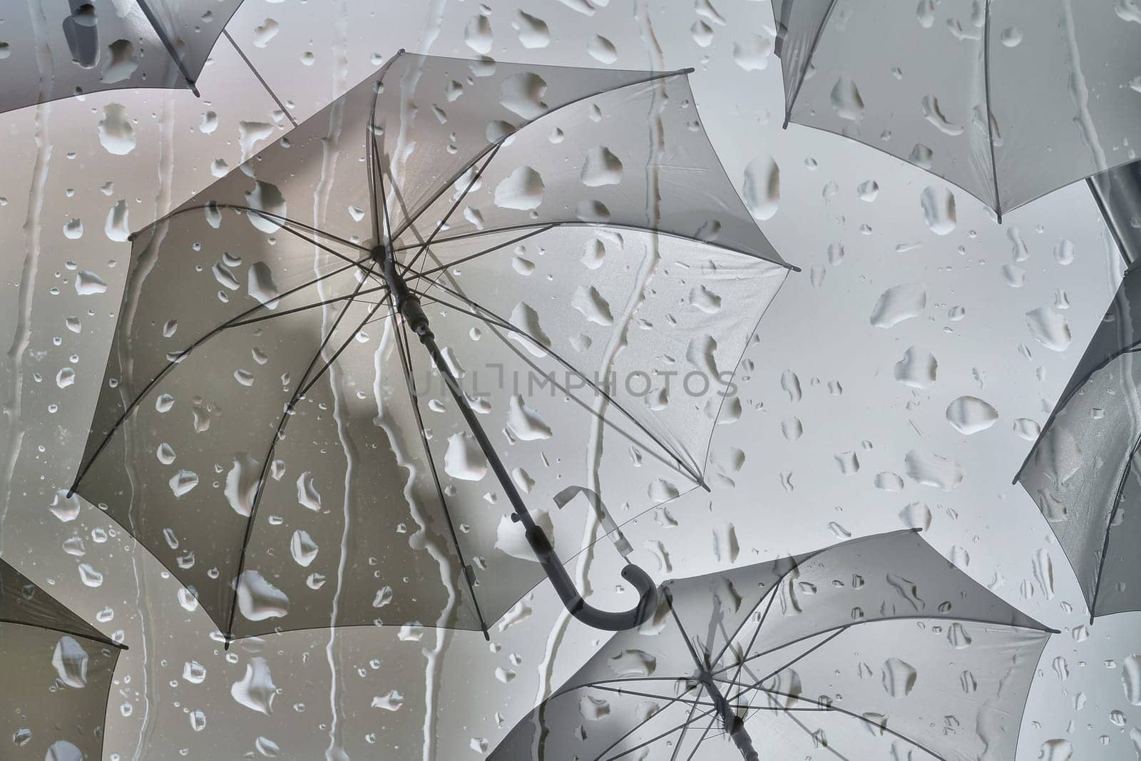 Superimposed images of raindrops and umbrellas as a representation of bad weather