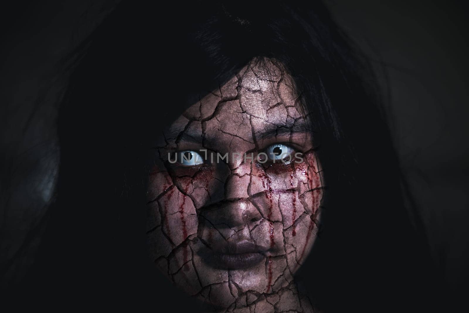Bloody halloween makeup. Asian woman with blood eye she death and scary with blood tear on broken face, Close up horror bloodthirsty ghost female fade drop out from eyes, Happy halloween day concept