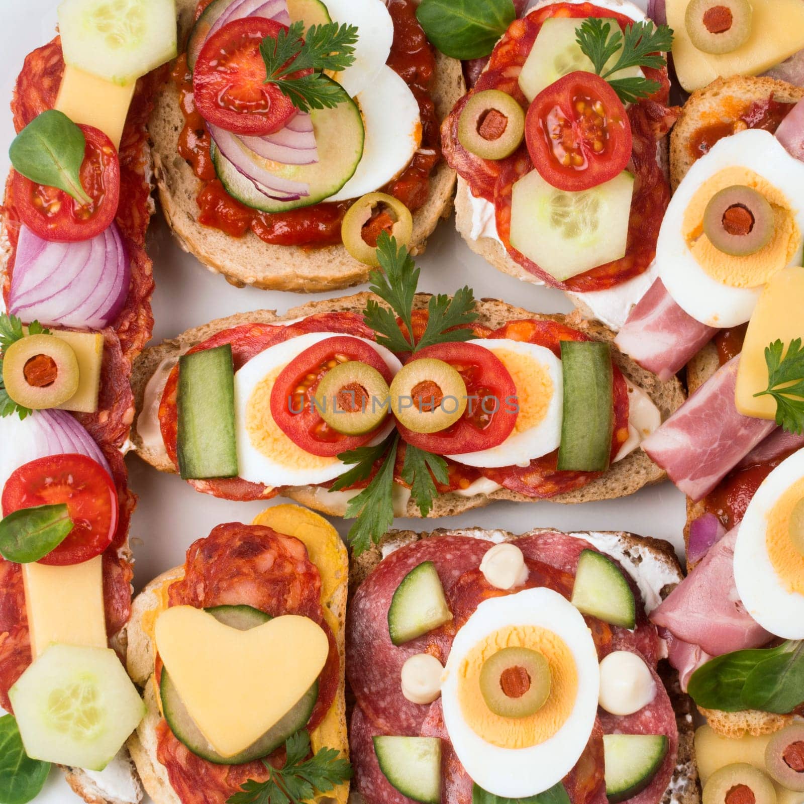 Top view close-up photo of different decorated sandwiches as appetizer.