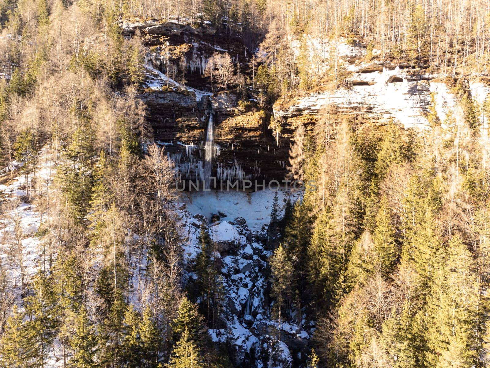 Aerial view of Pericnik slap or Pericnik Waterfall in winter time, Triglav National Park, Slovenia. Upper and lower waterfalls cascading over a rocky cliff, reachable by a picturesque walking trail