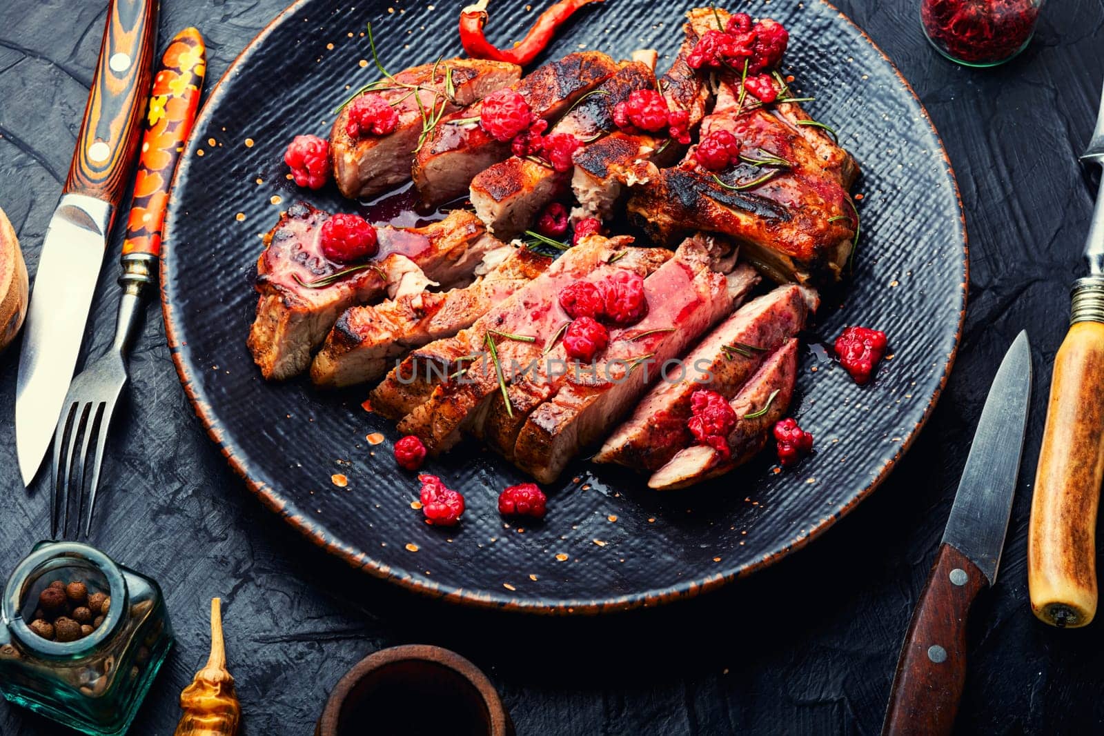 Roasted pork steak on a plate and raspberry sauce