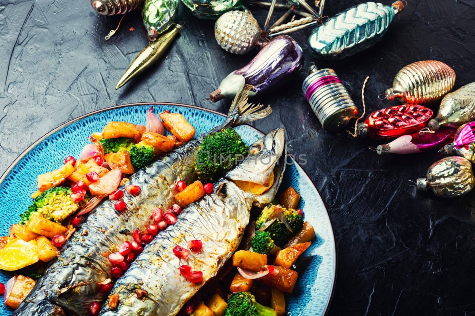 Baked whole fish with pineapple, broccoli and pomegranate. Grilled mackerel