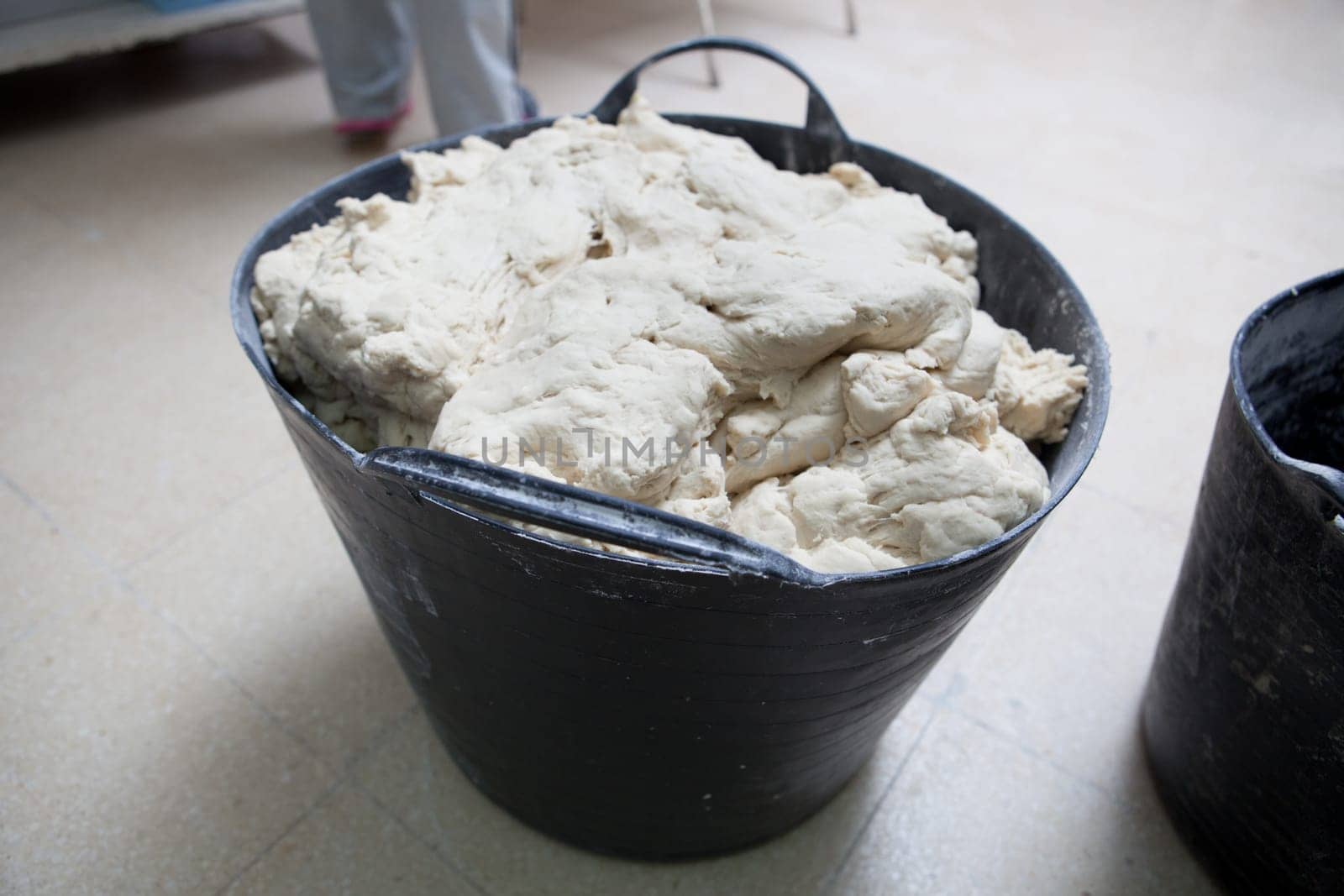 Bucket of dough for bread. Manufacturing process of spanish bread