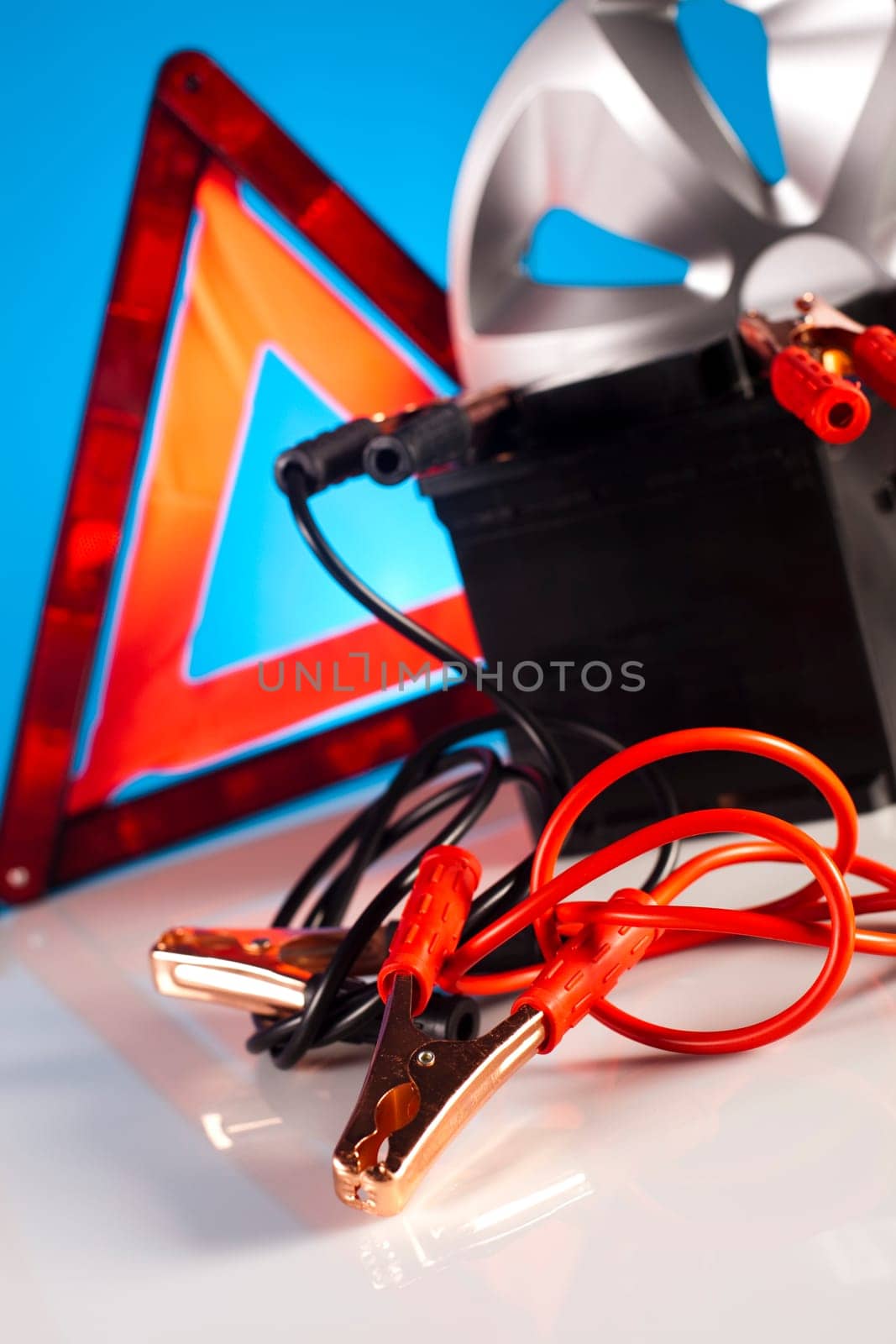 Car battery with two jumper cables clipped on vivid moto concept