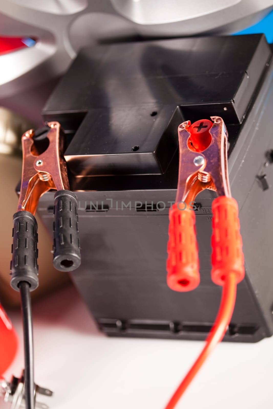 Car battery with two jumper cables clipped on vivid moto concept