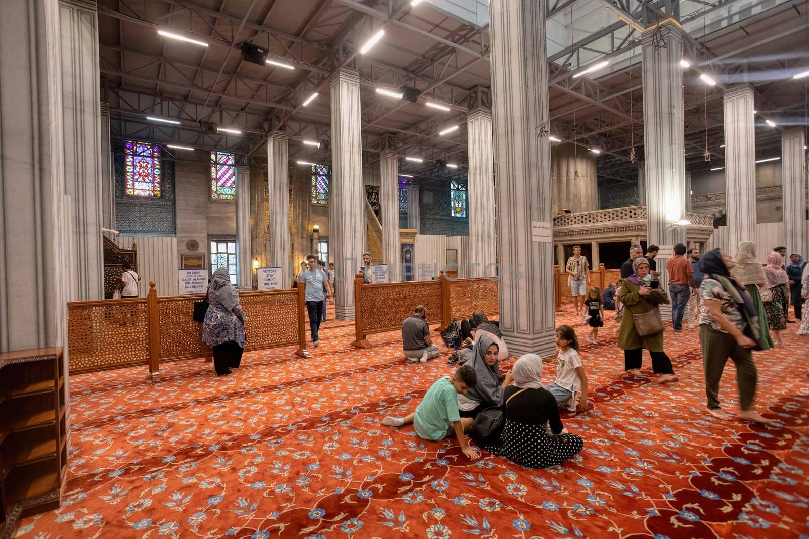 Istanbul, Turkey - August 5, 2022: Interior of famous Sultan Ahmed blue mosque with with prayers, Istanbul, Turkey