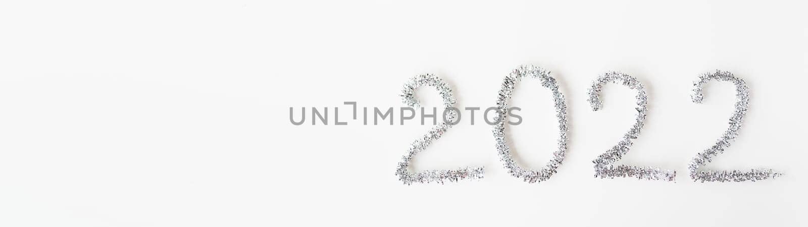 Baner happy new year 2022 written with foil and new year rain on an isolated white background. Happy new year greetings