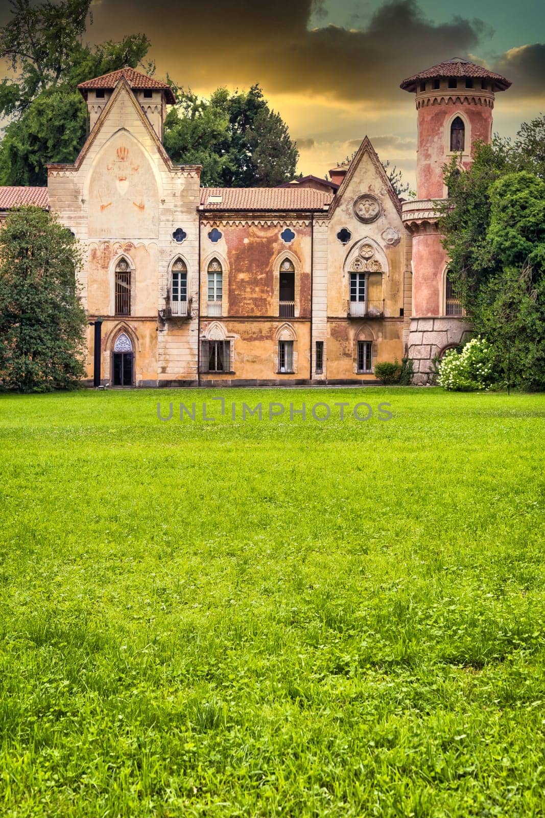 ITALY, MIRADOLO - CIRCA AUGUST 2020: gothic design castle located in an Italian garden, full of mystery, with sunset light.