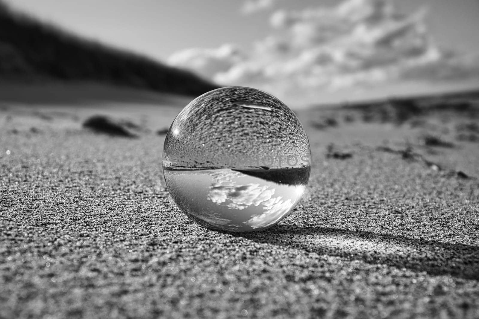 glass globe on the beach of the baltic sea. Black and white photograph