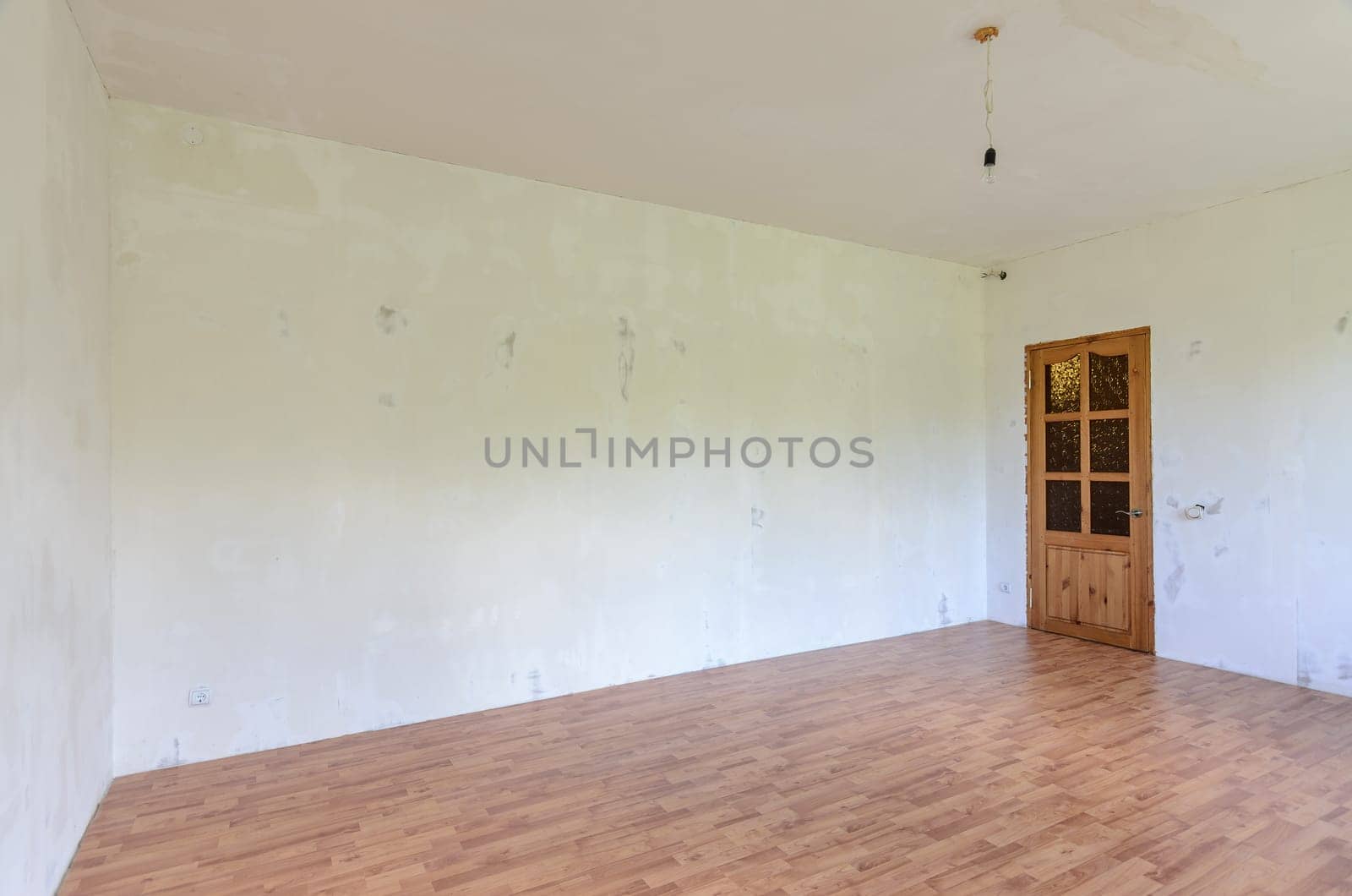 A fragment of the interior of a room with a fine finish, a view of the front door and an empty wall