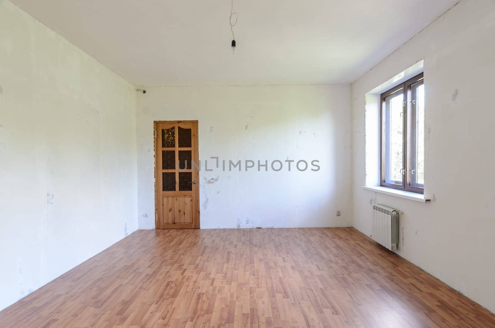 Fragment of a room with a fine finish, view of the front door, there is one window in the room