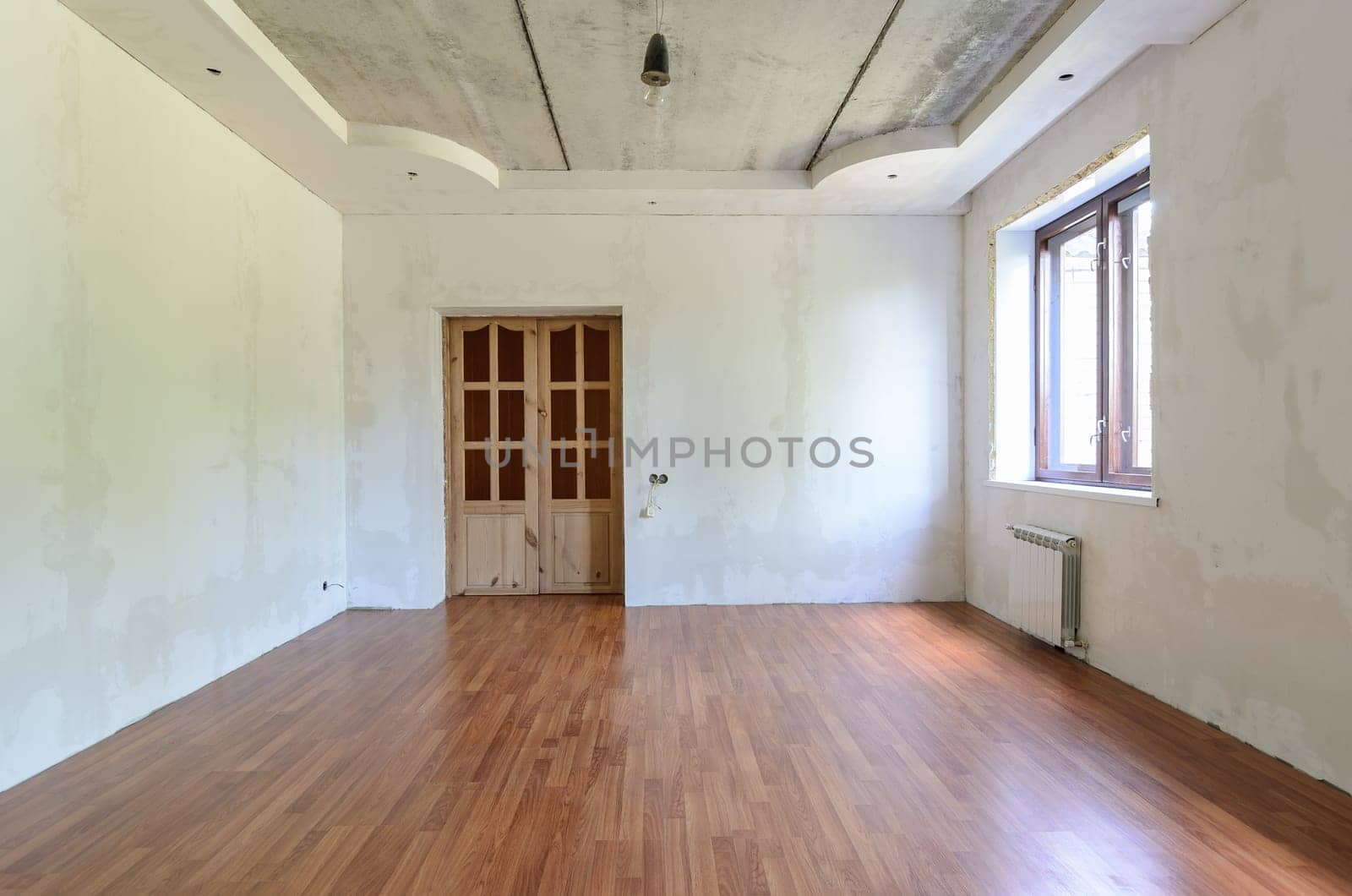 The interior of an empty room with a fine renovation, a laminate is laid on the floor