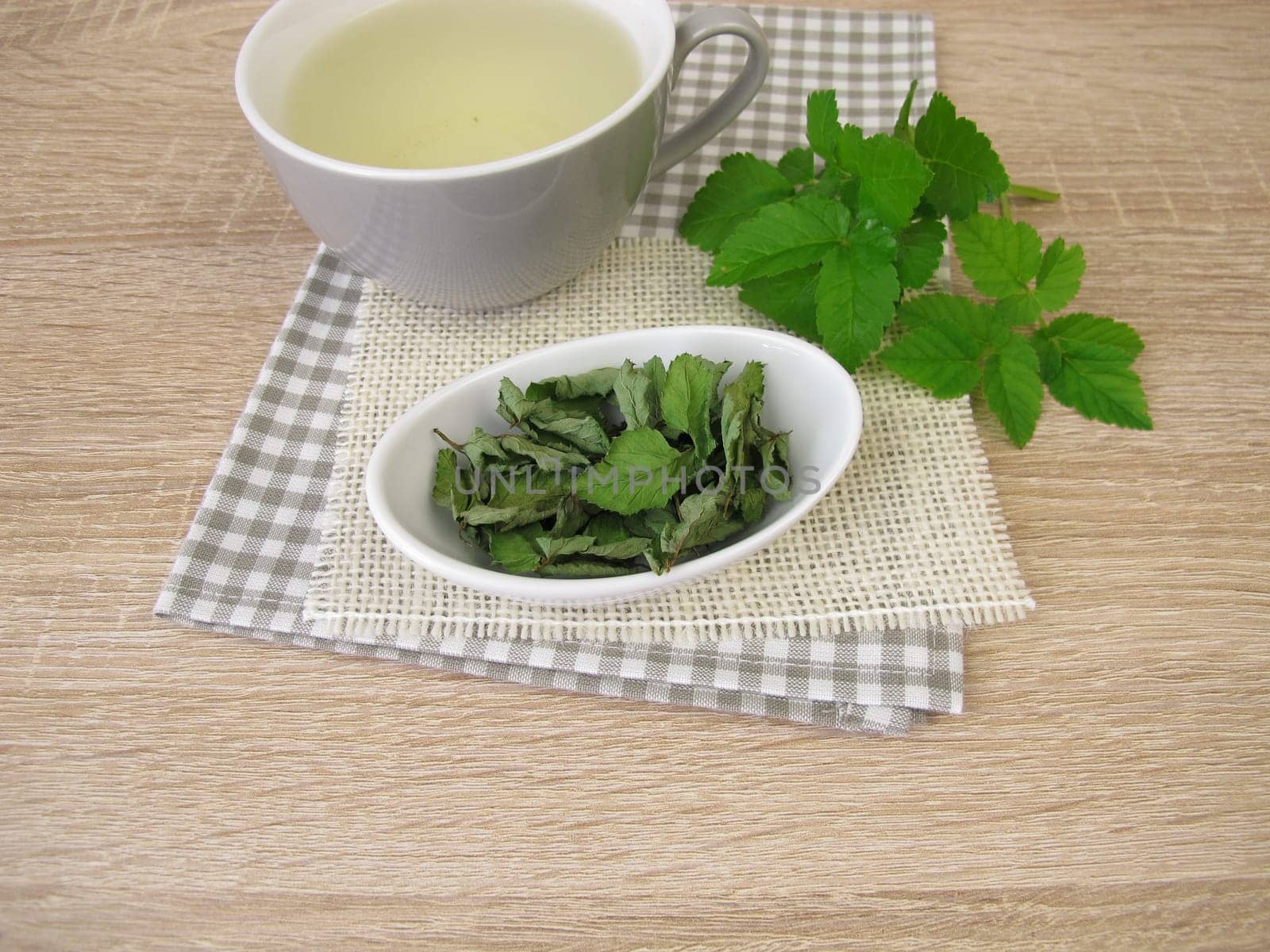 A cup of herbal tea with dried goutweed