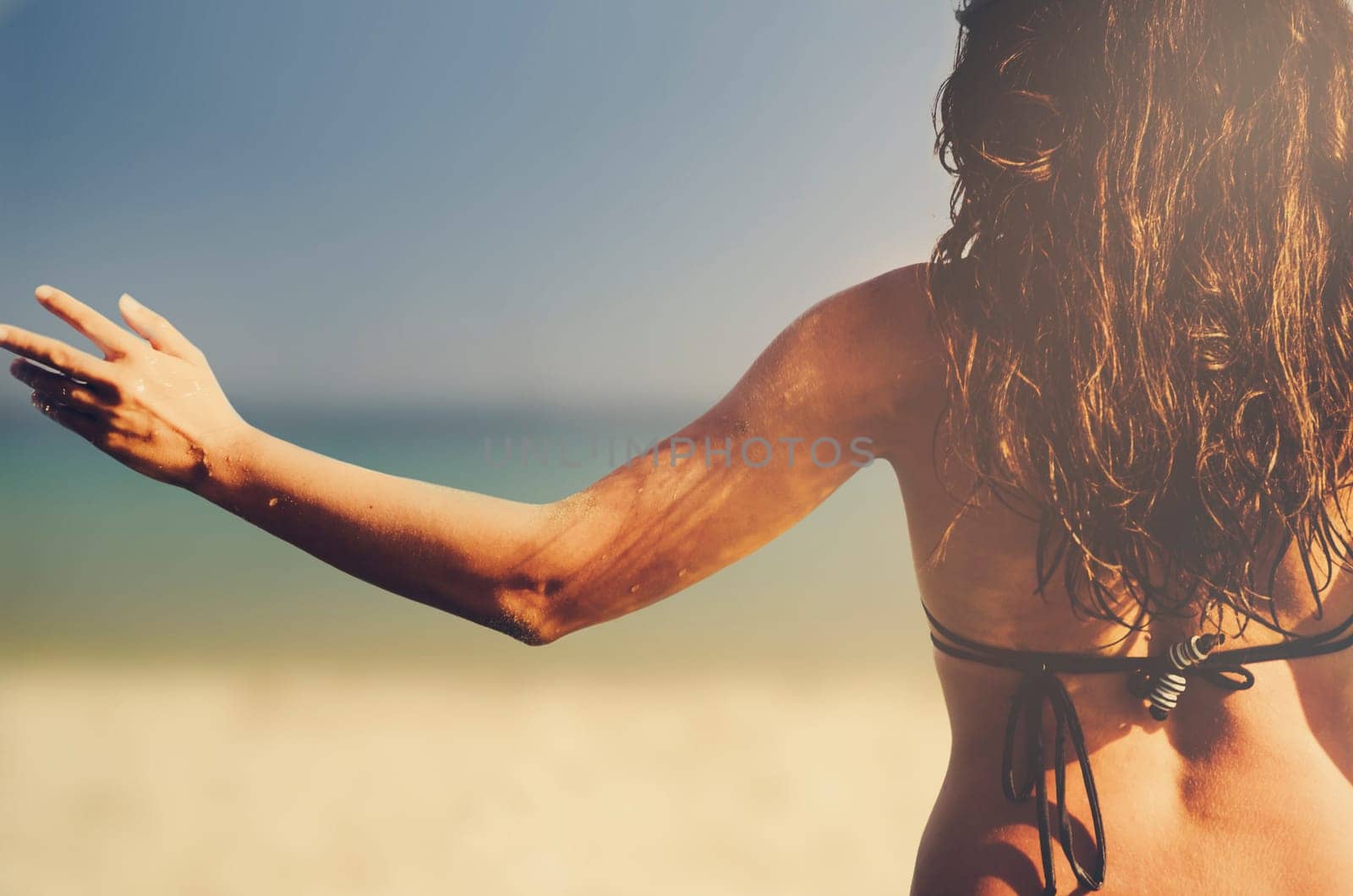Happy young woman from behind on resort beach having fun. Summer holiday travel to tropical island. Sexy hipster girl from back running to sea..
