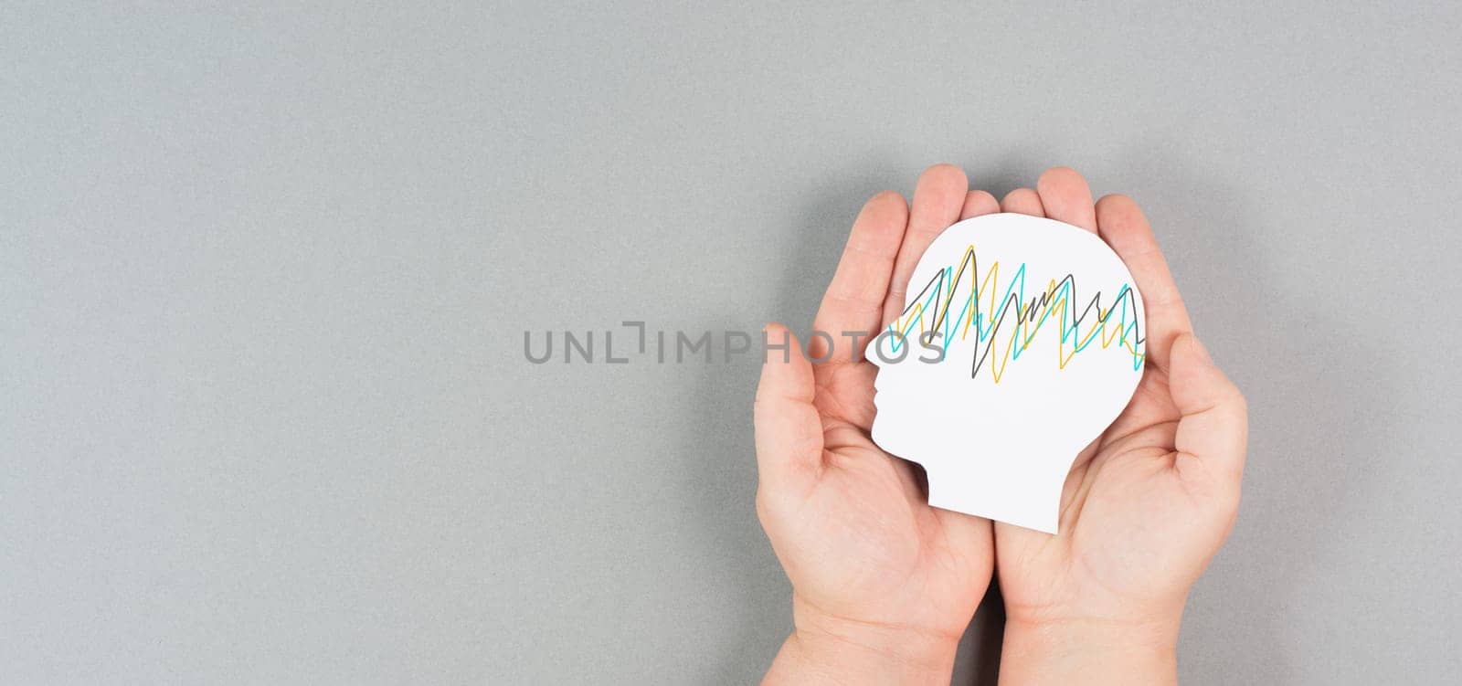 Holding a head in the hands, epilepsy disorder awareness, brain waves,mental health care, paper cut out