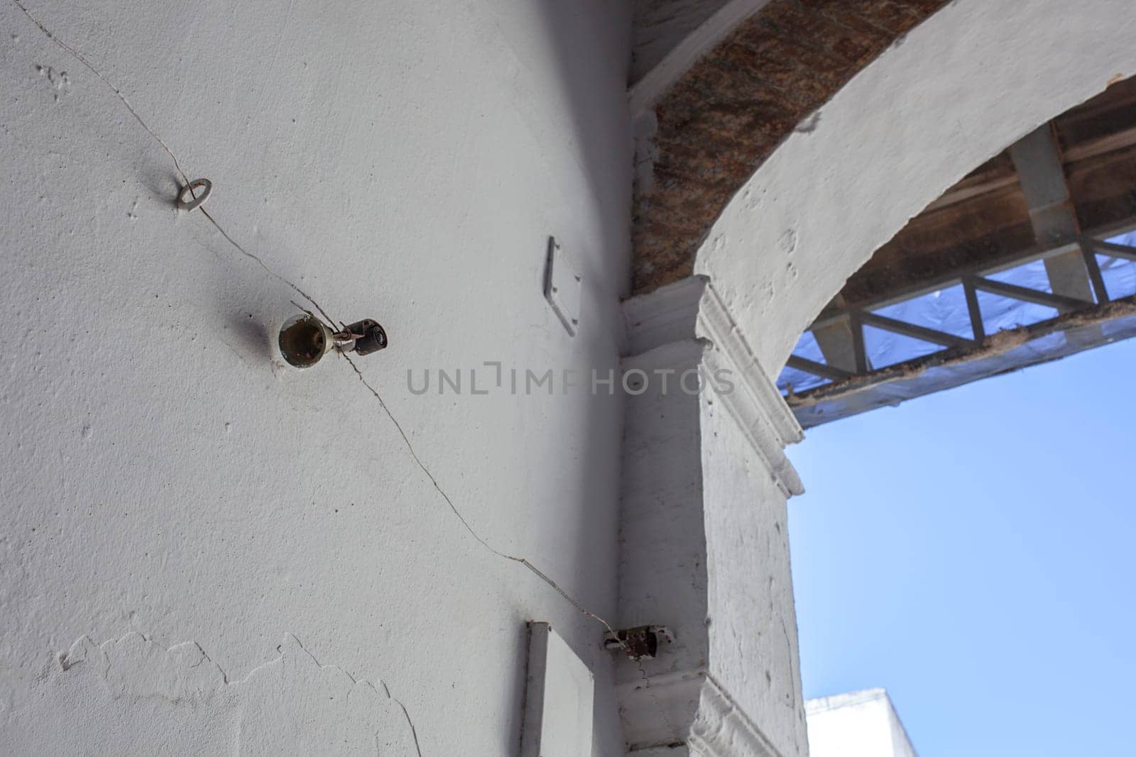 Mechanically operated doorbell on a torsion spring actuated by a wire. Bell nailed to whitewashed wall