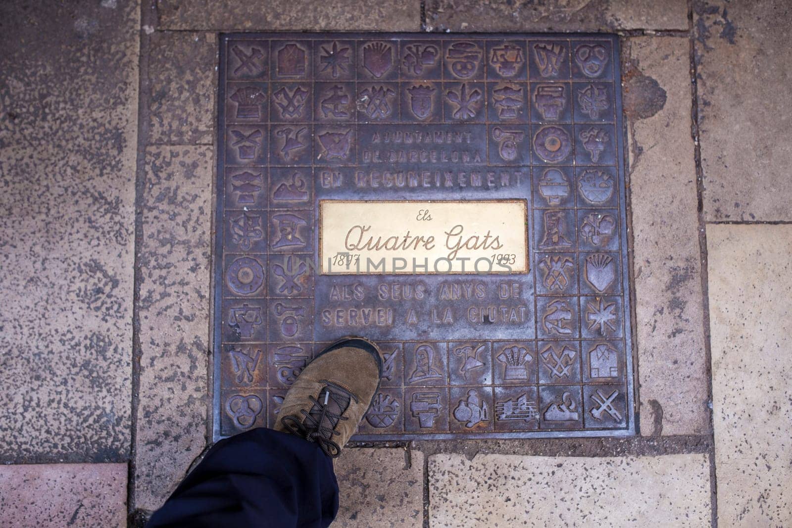 Barcelona, Spain - Dec 29th, 2019: Els Quatre Gats cafe. Winter visitor walking over ground plaque