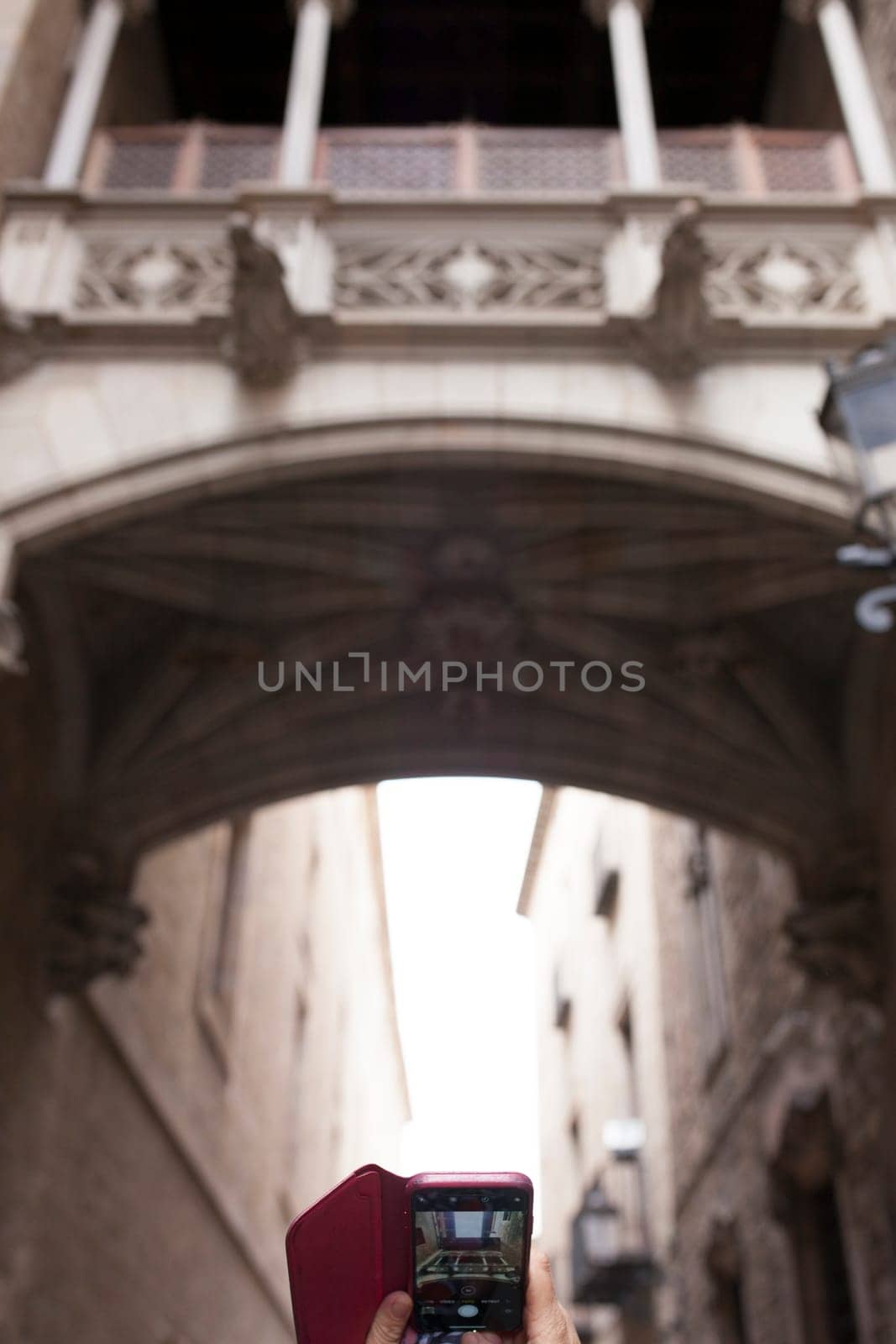 Tourist taking pictures to Bridge at Bisbe street, Barri Gotic, Barcelona. Spain