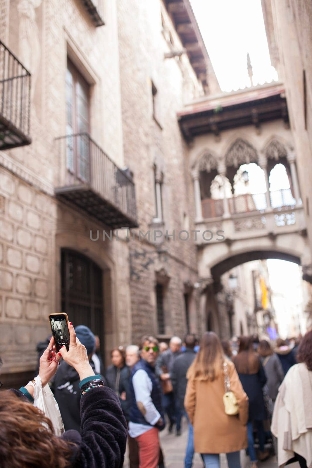 Tourist taking pictures to Bridge at Bisbe street, Barri Gotic, Barcelona. Spain