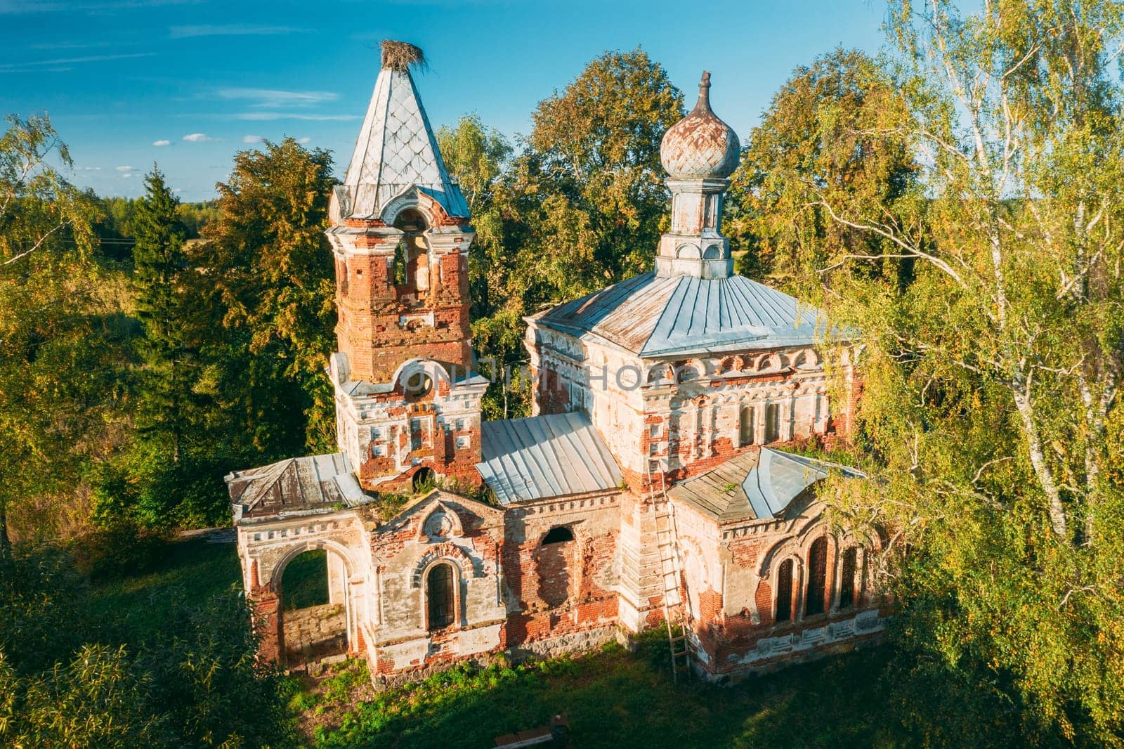 Martinovo, Beshenkovichsky District, Vitebsk Region, Belarus. Bird's-eye View Of Church Of The Intercession Of The Most Holy Theotokos. Aerial View Of Historic Landmark In Autumn Sunny Evening.