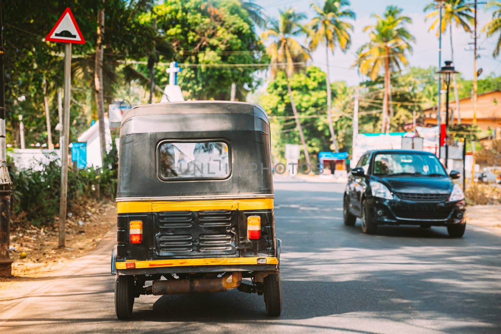 Goa, India. Auto Rickshaw Or Tuk-tuk Moving On Street. Back View.