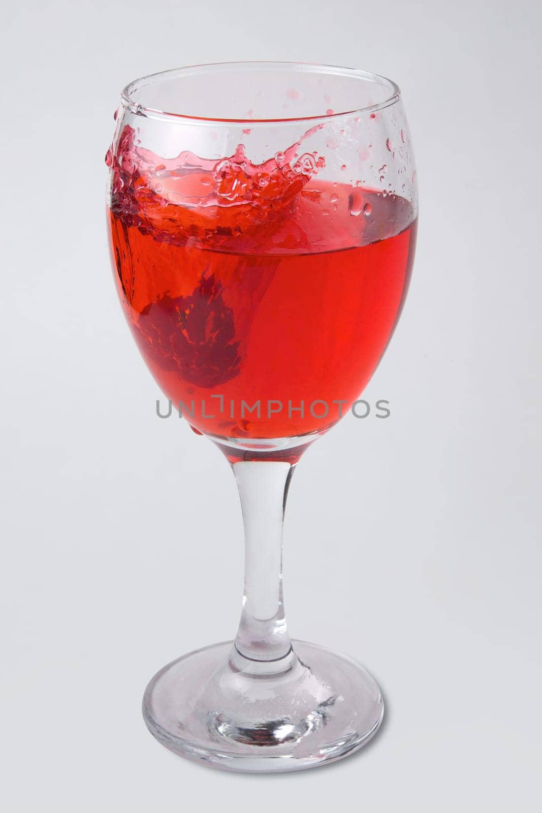 raspberry splashing into glass of wine red juice drink splash water drop on white background