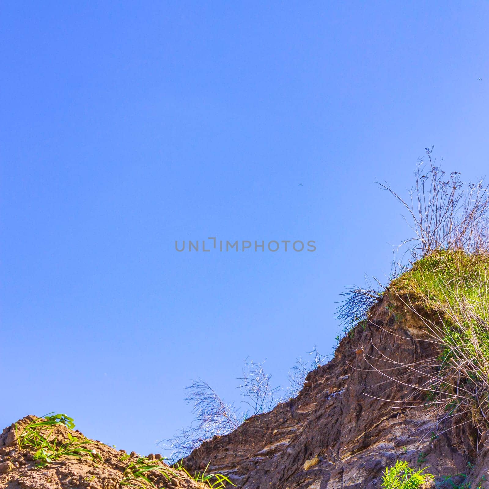 Excavated sand mountains and rubble piles quarry lake dredging pond lake with blue sky and landscape nature forest panorama view in Eggestedt Schwanewede Osterholz Lower Saxony Germany.