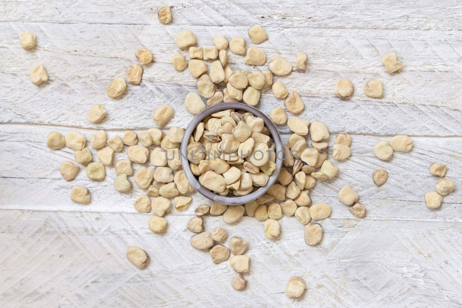 Bowl of raw dry Grass pea on wood top view. Healthy, protein source for vegan and vegetarian diet. Traditional Italian apulian cuisine ingredient. Legumes known as Cicerchia, Vetch, Blue Sweet Pea