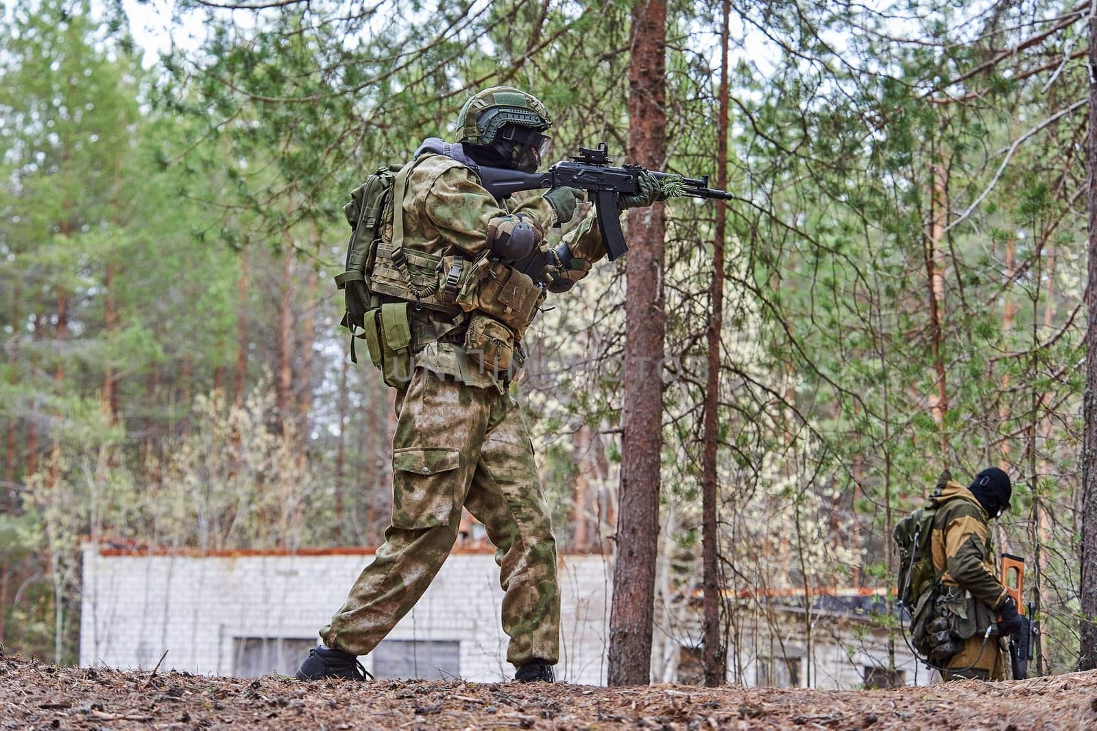 a man in the forest shoots from a machine gun. High quality photo