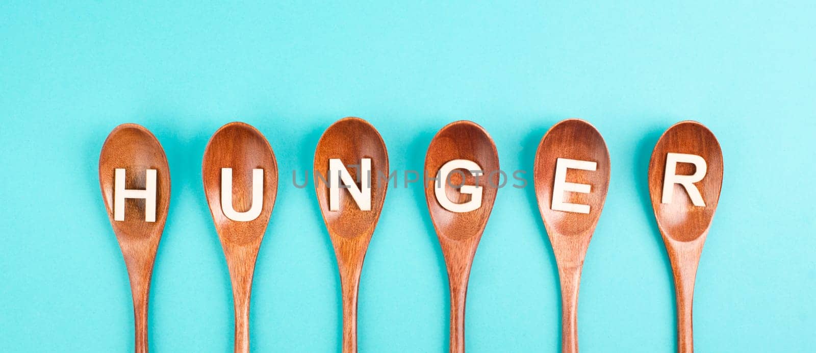 Hungry is standing in german language on the wooden spoons, food shortage and starving because of the war and inflation, political issue