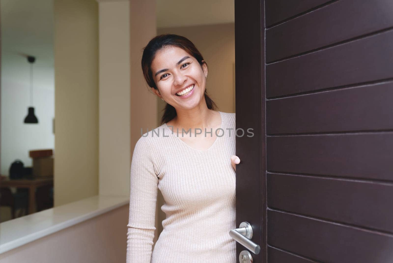 smiling woman opening the door welcome to the house
