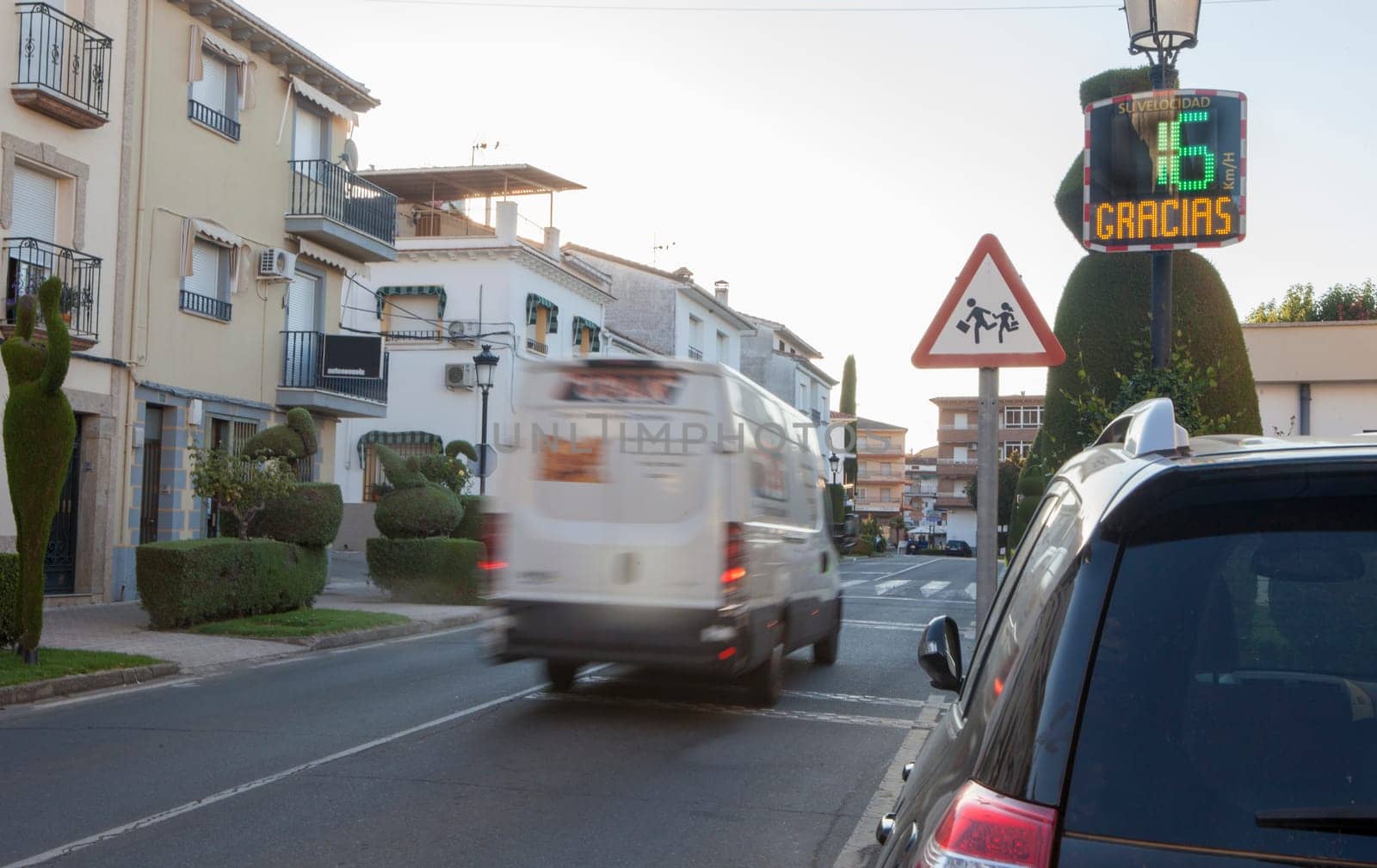 Vehicule crossing close to radar speed sign pole. Low motion shot