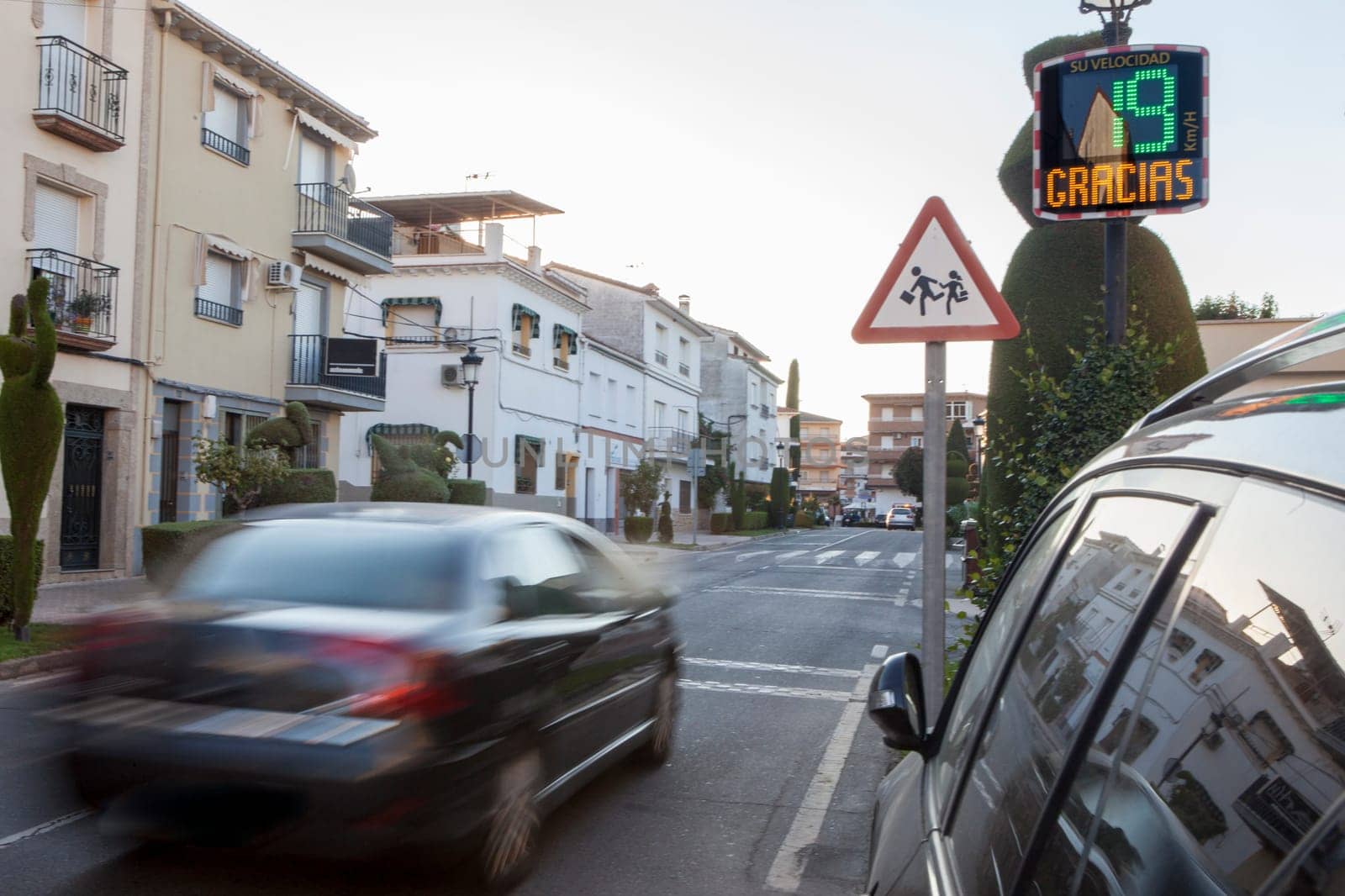 Vehicule crossing close to radar speed sign pole. Low motion shot