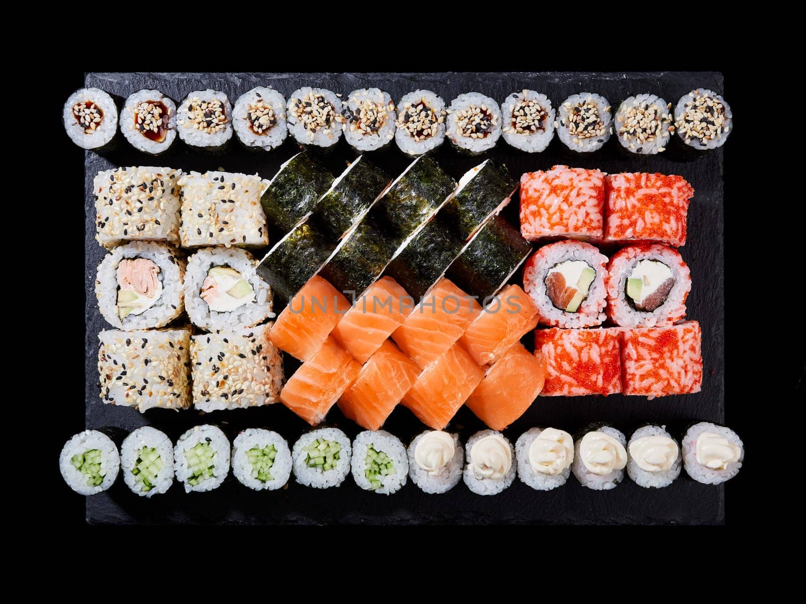 Top view sushi set. Philadelphia roll, california, unagi, black dragon with fresh ingredients on black background. Sushi menu. Japanese food.