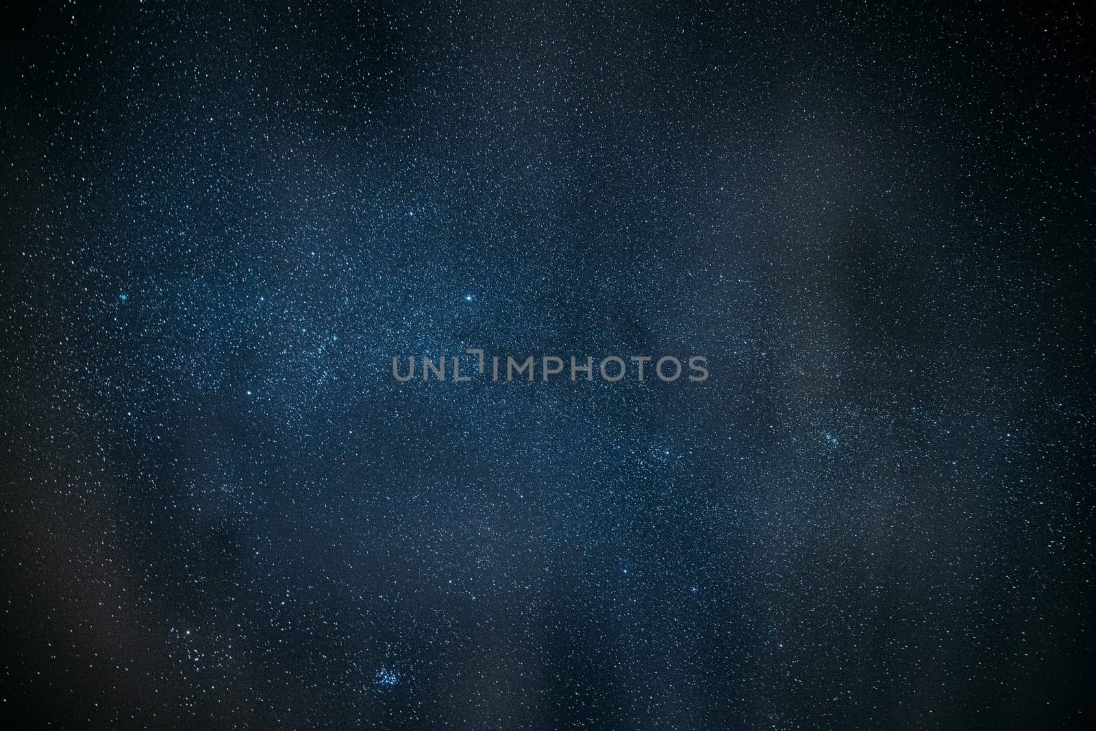 Milky Way Galaxy Glowing Through The Light Cloudiness Overcast. Real Night Sky Stars. Natural Starry Sky Dark Black Background Backdrop.