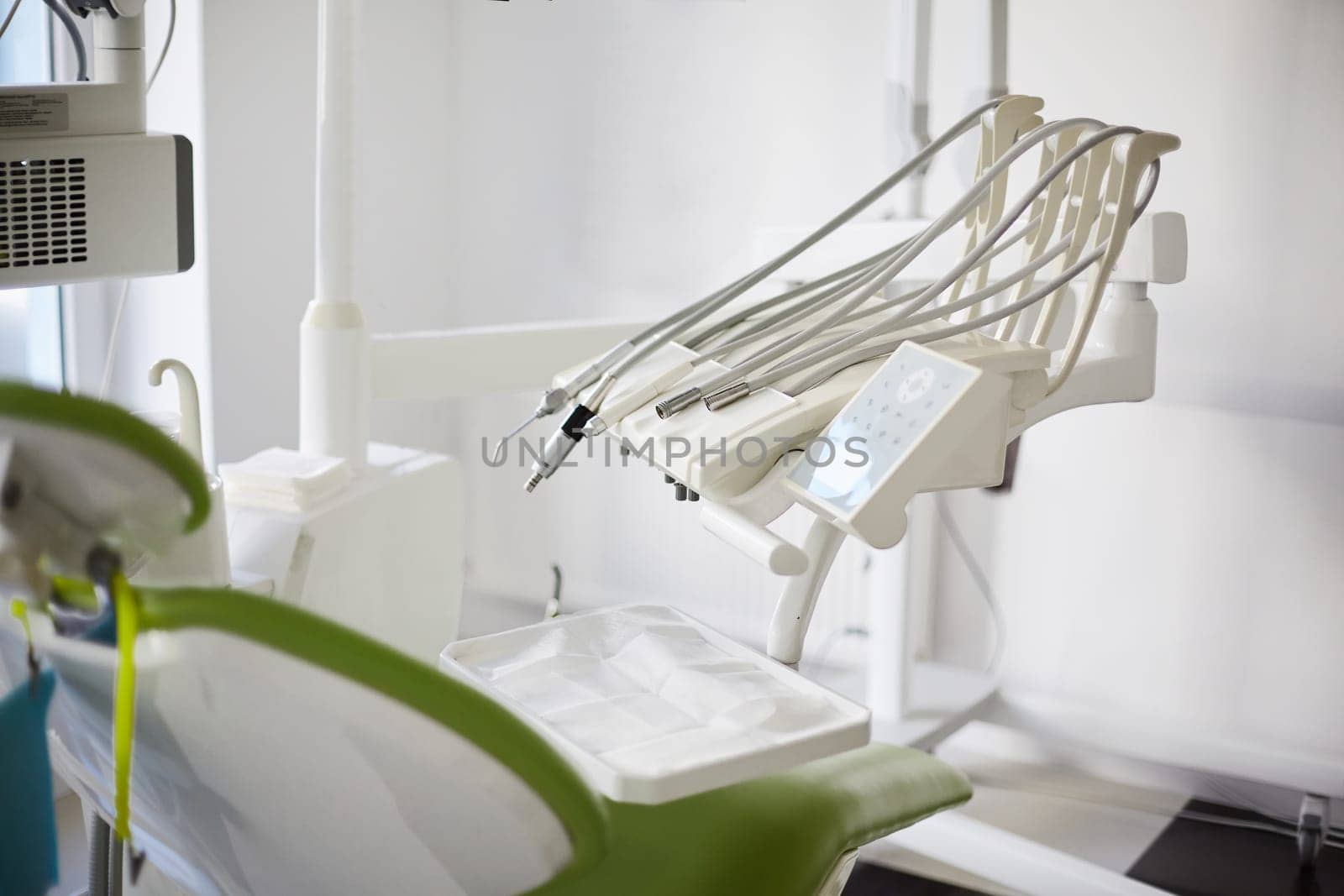 Special equipment for dentist. Equipment and dental instruments in bright modern dentist's office. Variety of medical instruments are arranged on side of dental chair. Selective focus.