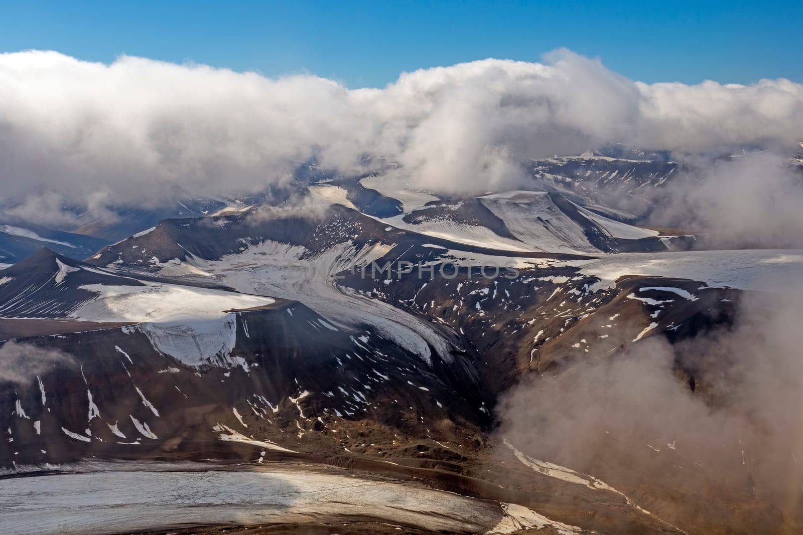 Glaciers and Mountains Appearing Through the Clouds Over the Svalbard Islands in Norway