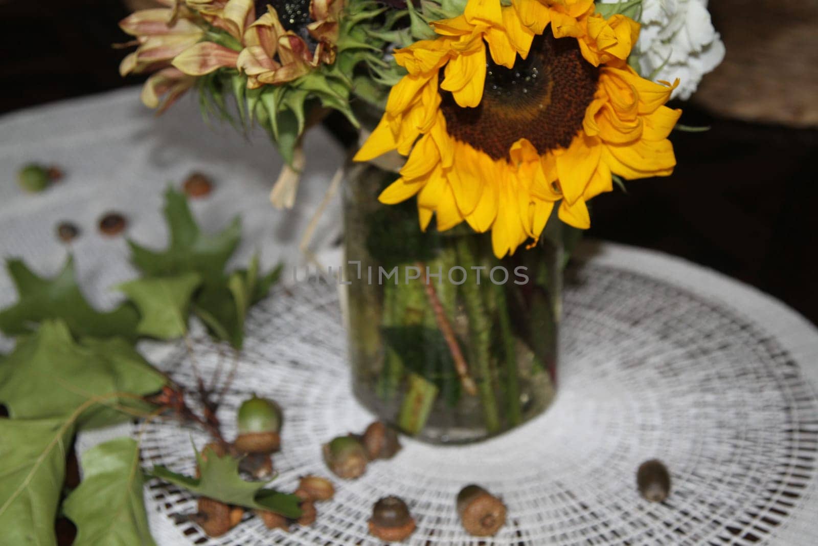 Mason jar with sunflowers and wildflowers bouquet, oak leaves and acorns