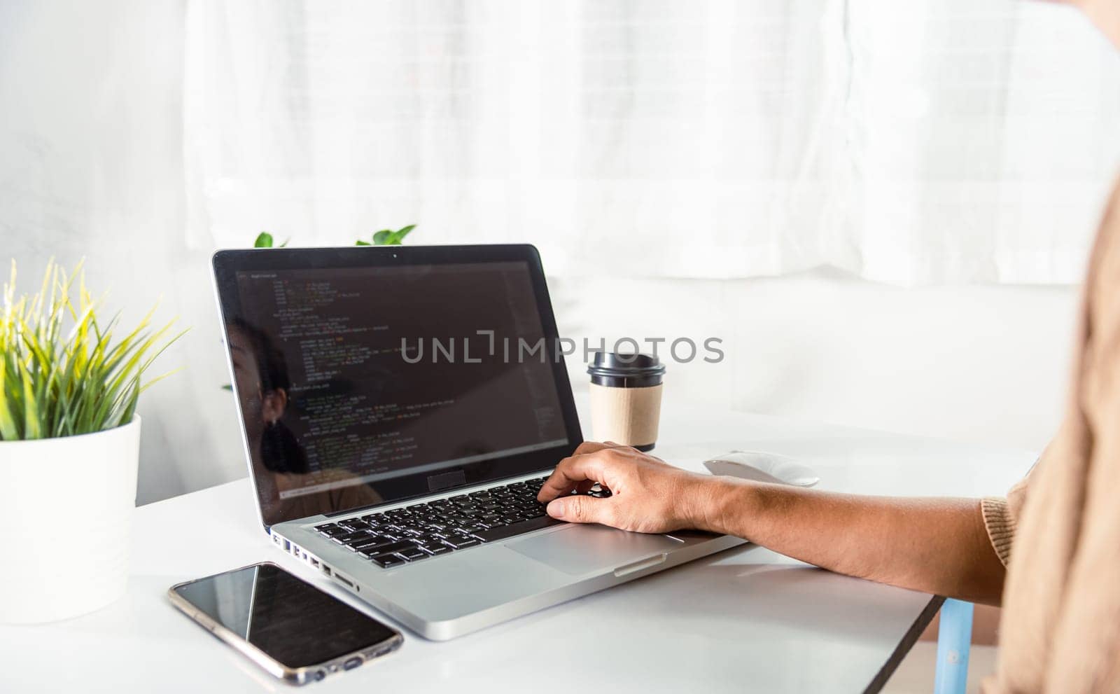 Programmer woman writing program HTML code sitting at workplace in office, IT software developer hands typing data coding programming with laptop computer, IT start up concept, Web application design