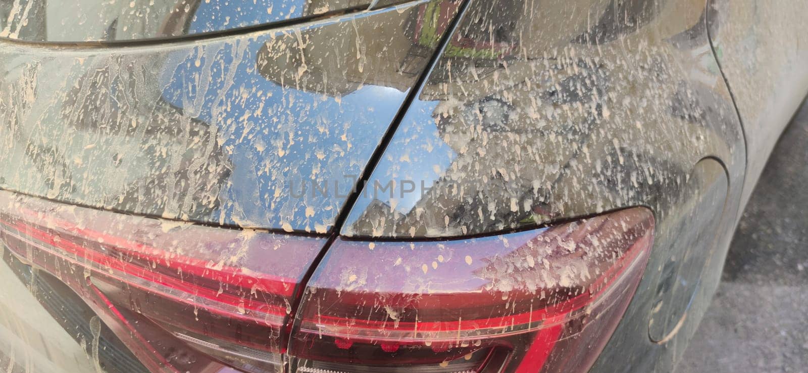 Rain dust drops stains over trunk car door. Closeup