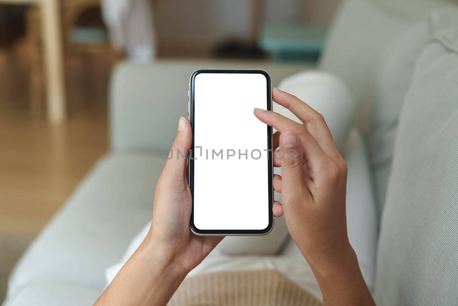 close-up hand using phone showing white screen in living room