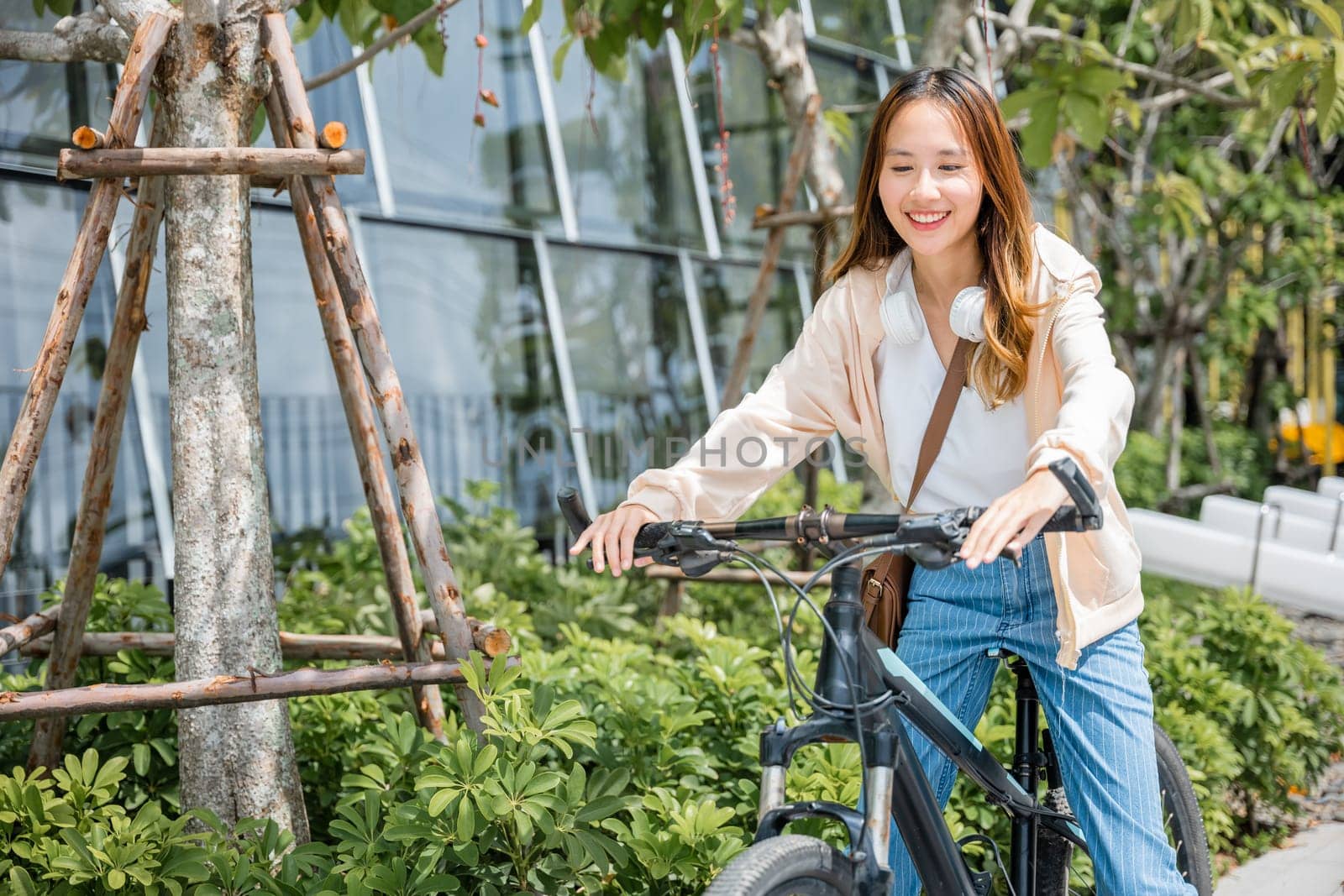 Happy Asian beautiful young woman riding bicycle on street outdoor near building city, Portrait of smiling female lifestyle using bike in summer travel means of transportation, ECO friendly